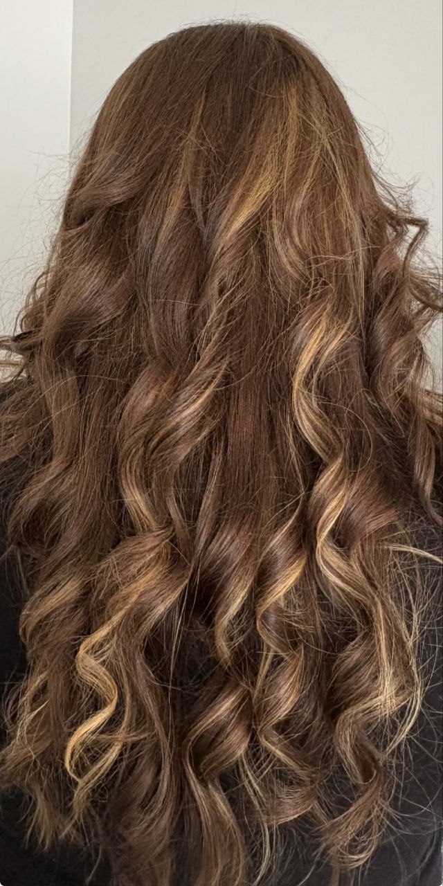 After photo of dimensional brunette hair with caramel highlights and curls